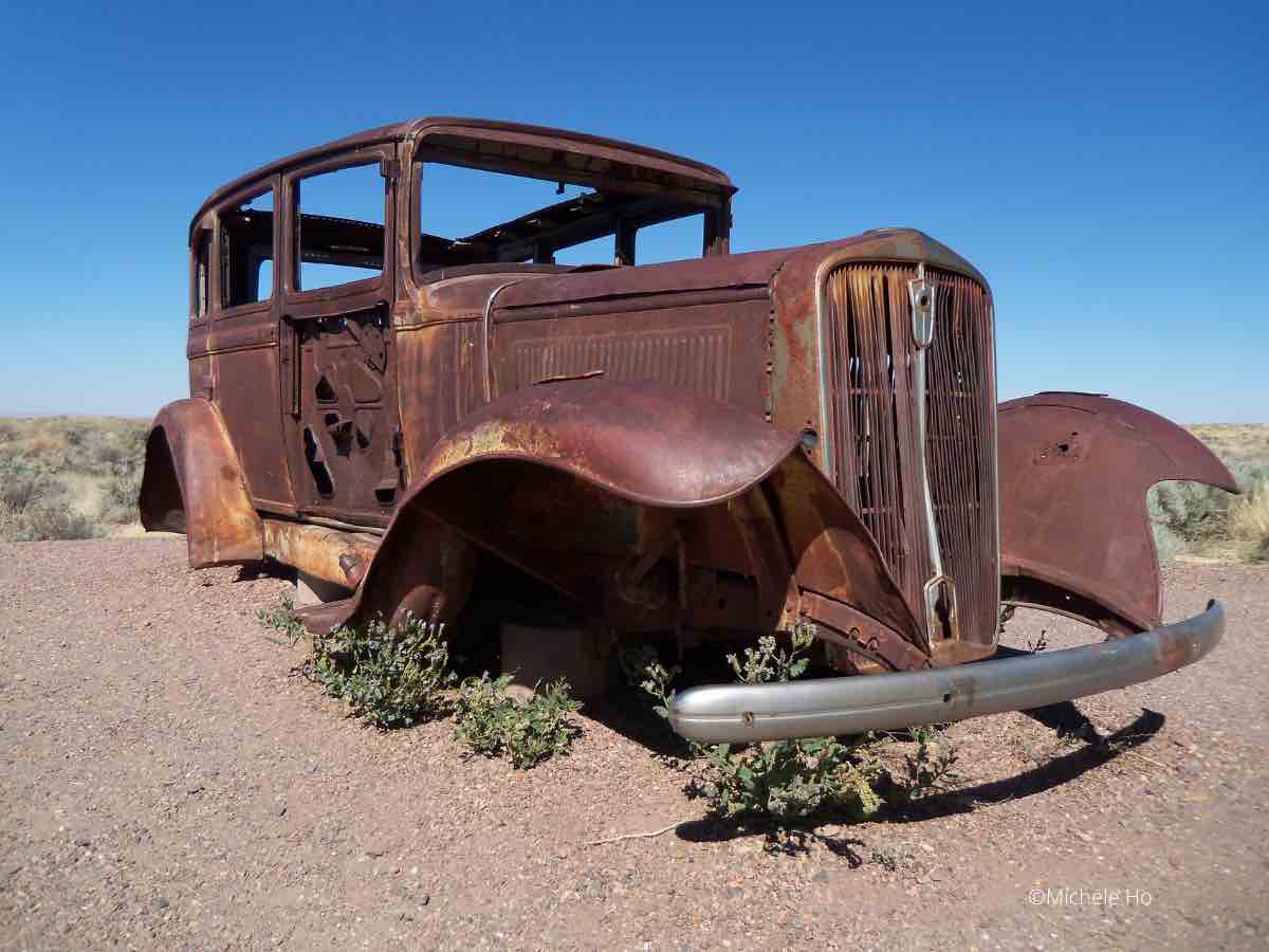 rusted vintage car sitting on the side of Route 66